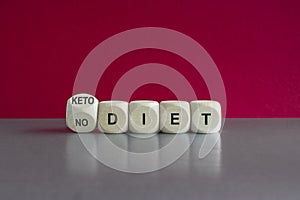 Turned a wooden cube and changes the expression No diet to keto diet. Beautiful grey table, pink background