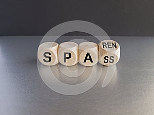 Turned a wooden cube and changes the German word spass to sparen. Beautiful grey table black background. Symbol for saving money photo