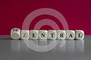 Turned wooden cube and changes the German word zentral to dezentral