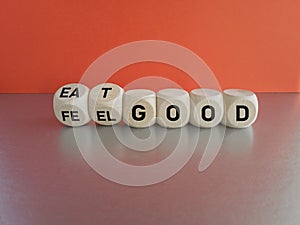 Turned wooden cubes and changes the word feel good to eat good. Beautiful wooden table, red background
