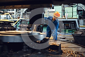 Turner stanging at the automated lathe, factory photo