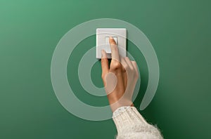 Turning on light switch against green wall