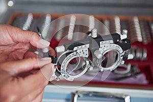 Turning the pieces. Female hands holding the optical device for eye testing