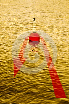 At the turning point - concept image with a red bouy on a calm golden lake and red arrow