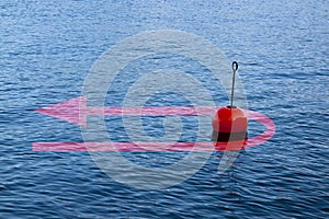 At the turning point - concept image with a red bouy on a calm lake and red arrow that comes back