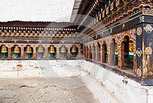 Turning prayer wheels  in Bhutan with traditional mantra whriting on them which sounds as Om mani padme hum, literally means Oh, j photo