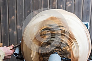 Turning wooden bowls on a lathe. The close up view of spinning the lathe machine
