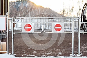 Turnstile at the exit of the ski lift with a stop sign and chrome pipes in the Altai mountains