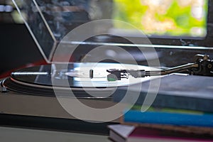 A turntable headshell record player with blur stack of book in front