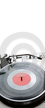 Turntable in silver case with vinyl record with red label isolated on white background top view