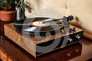 turntable with spinning vinyl record, stylus and dust cover