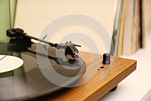 Turntable with vinyl record on white table, closeup. Space for text