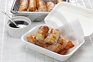 Turon, filipino banana spring rolls in takeaway container photo