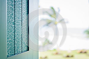 Turqoiuse painted window shutter overlooking the ocean photo