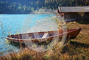 turquoise alpine lake lautersee with moored rowing boat an boathouses