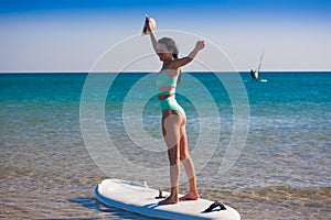 Turquoise bikini sea, surfing board, sunglasses, smile