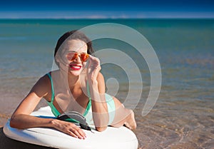 Turquoise bikini sea, surfing board, sunglasses, smile