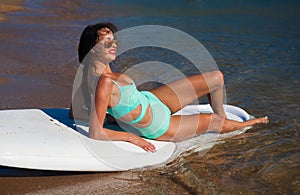 Turquoise bikini sea, surfing board, sunglasses, smile