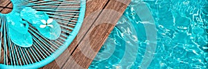 Turquoise blue garden chair and flip flops on on the edge of a swimming pool