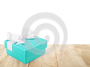 turquoise blue gift box with simple ribbon bow on wooden table floor