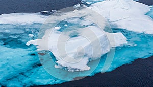 Turquoise blue glacier ice floats in the Arctic Ocean