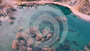 Turquoise blue mirror water with trees in the lake