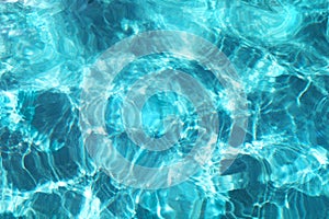 Turquoise blue rippled water surface of swimming pool. Summer vacations resort.
