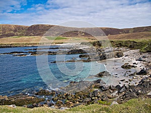 With turquoise, clear water and white sand, a beach at Collaster on the west coast of the island of Unst in Shetland, UK