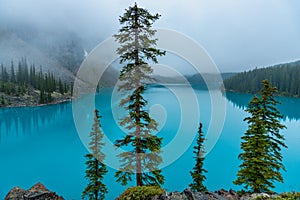 Turquoise color beautiful Moraine Lake during foggy morning