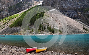 Turquoise color Moraine Lake with red and yellow canoe in Banff national park, located in Canadian Rockies in Alberta Canada