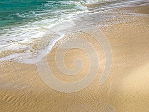 Turquoise colored waves on a beach