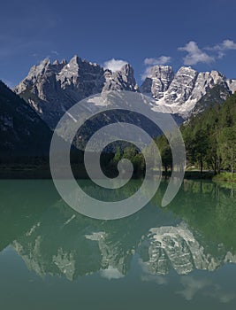 Turquoise coloured lake Duerrensee with view to and refelction Christallo mountain range in Dolomite Alps, South Tyrol Italy