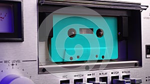 Turquoise Compact Audio Cassette Tape Playing in Vintage Deck Player