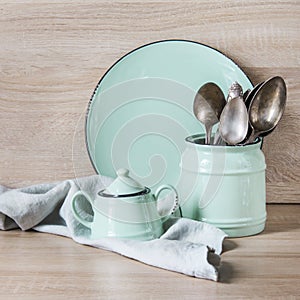 Turquoise crockery, tableware, dishware utensils and stuff on wooden table-top. Kitchen still life as background for design.