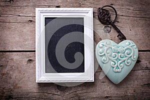 Turquoise decorative heart, empty blackboard and vintage key