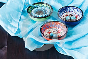 Turquoise earrings on bowl. Fashion background