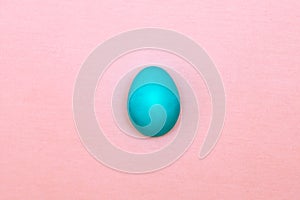 Turquoise easter egg on a pink background. Easter concept.