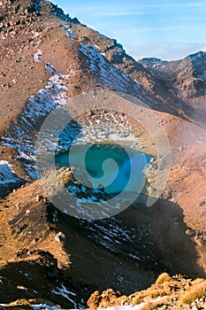 Turquoise emerald lake view and active volcano, smoking sulphur from surreal volcanic terrain, Tongariro National Park