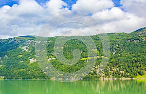 Turquoise green water of fjord river mountains landscape of Norway