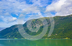 Turquoise green water of fjord river mountains landscape of Norway