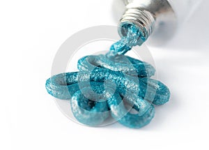 Turquoise hair color squeezed out of a tube on white background. Concept of hair dye, trendy hair styling or salon