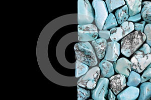 Turquoise heap stones texture on half black background. Place for text