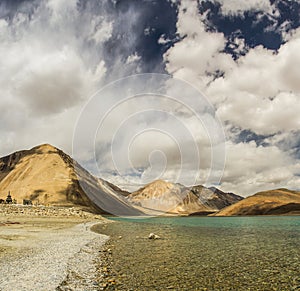 Turquoise lake in the Himalayas tibet mountains with clouds and blue sky