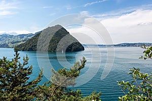 Turquoise lake with a yacht and a green mountain