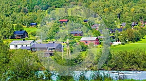 Turquoise meltwater flows in a river through village in Norway