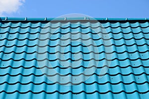 Turquoise metal tiles on roof of the house. Modern roofing materials