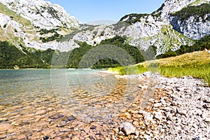 Turquoise mountain lake with crystal pure waters surrounded by rocky mountains