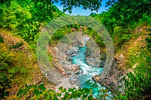 Turquoise mountain river flows in a mountain canyon