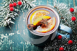 Turquoise mug of christmas mulled wine or gluhwein with spices and orange slices on wooden teal table. Traditional drink on winter photo