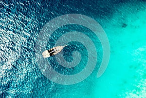 Turquoise ocean water with boat on it top view